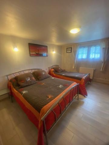 a bedroom with two beds in a room at Chambres et table d'hôtes Floromel La Souterraine en rez de chaussee in La Souterraine
