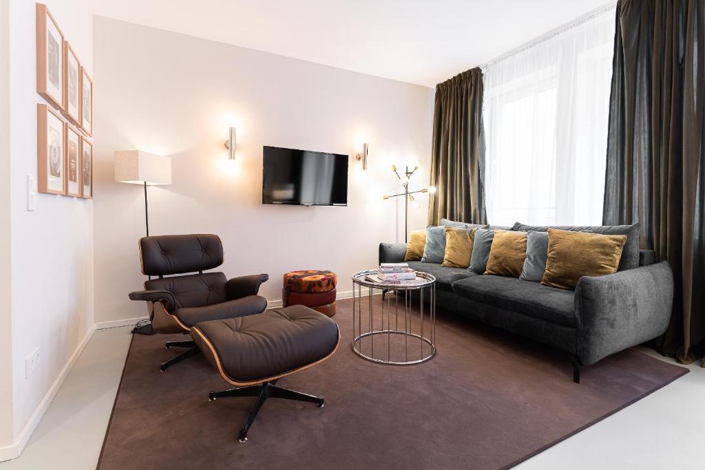 a living room with a couch and a chair at HeyMi Apartments Mondschein in Vienna