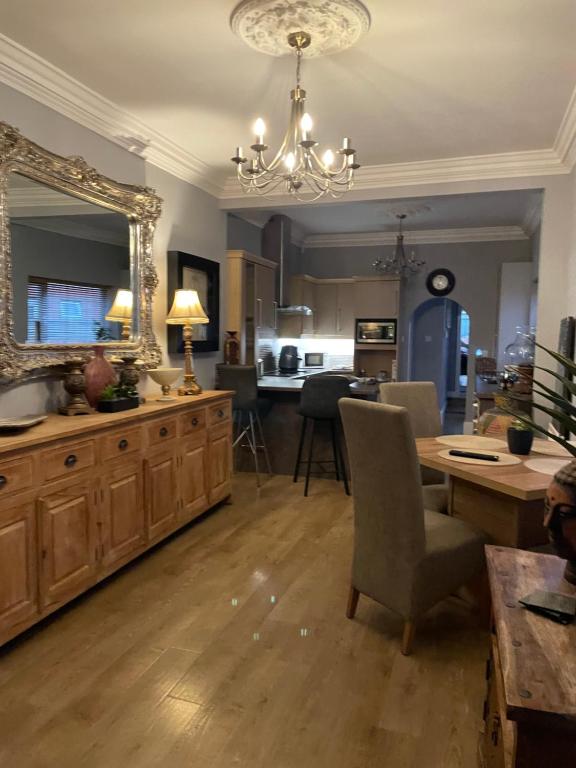 ein Wohnzimmer mit einem großen Spiegel und einem Tisch in der Unterkunft The Vines Lodge luxury apartment in Cleethorpes