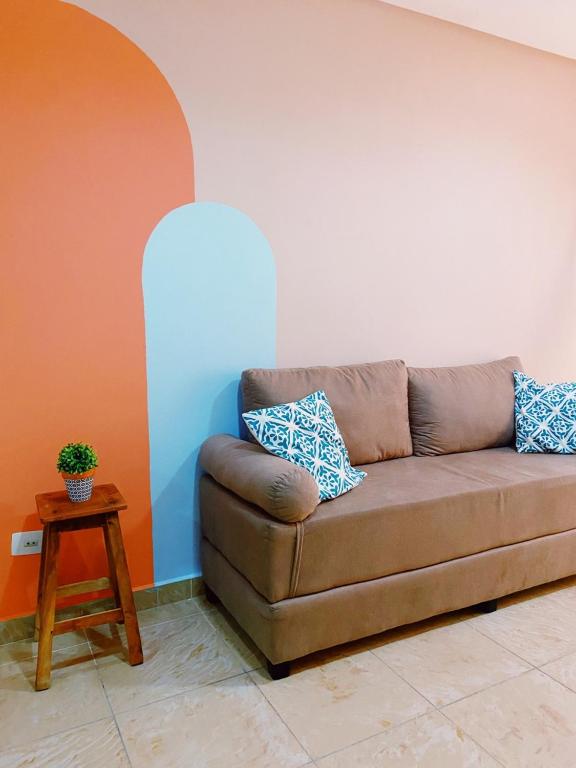 a brown couch in a living room with a table at Studio Aurora - Recife in Recife