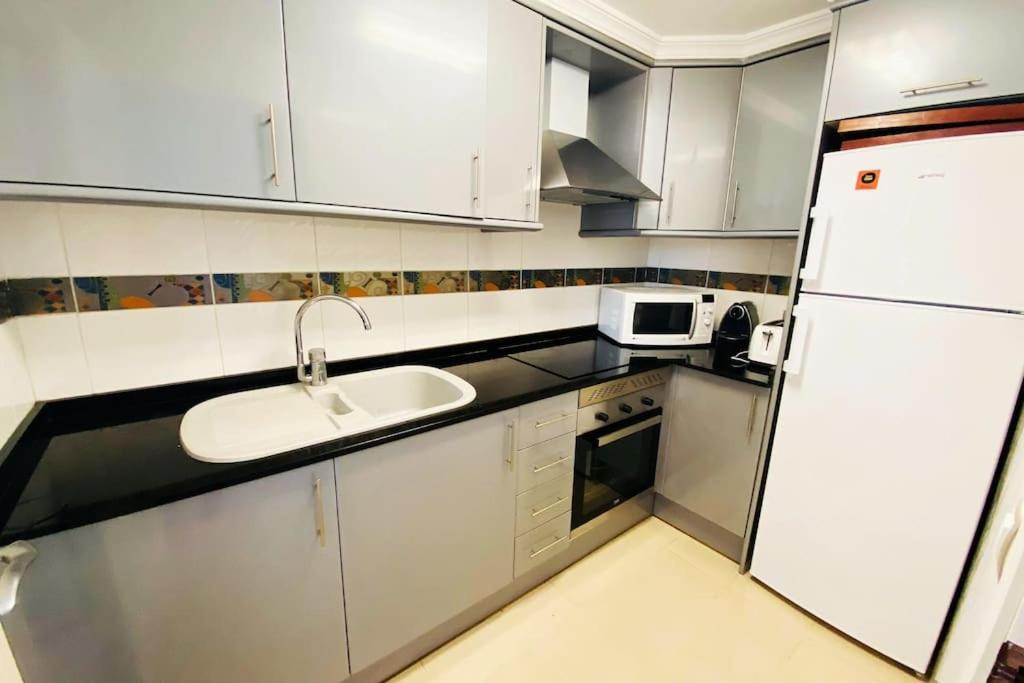 Kuchyň nebo kuchyňský kout v ubytování Apartamento en primera línea de playa con piscina y garaje gratuito