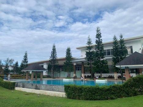 a large building with a swimming pool in a yard at Suēlo at Cool Suites at Wind Residences Tagaytay in Tagaytay