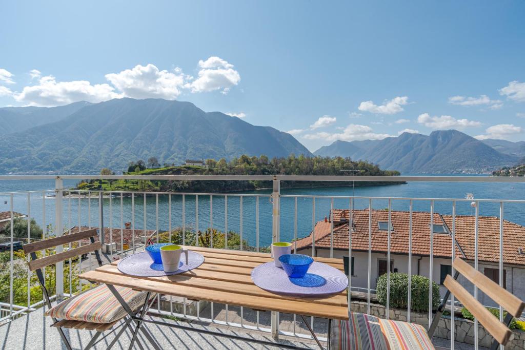 una mesa en un balcón con vistas al agua en Lake Como Apartment with Balcony and Private Parking, en Ossuccio