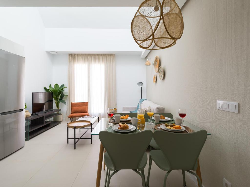 comedor con mesa y sillas en la sala de estar en Royal Suites, en Las Palmas de Gran Canaria