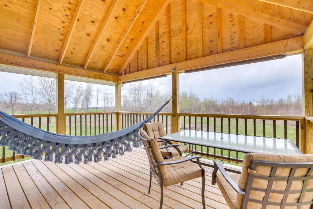 uma rede de descanso num alpendre coberto com uma mesa e cadeiras em Cozy Solar-Powered Loft Walk to Lake Champlain! 