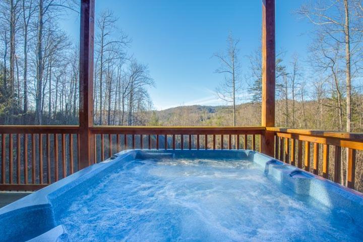 bañera de hidromasaje en la cubierta de una casa en Apple Bear Lodge, 4 Bedrooms, Sleeps 18, Jacuzzis, Pool Table, Hot Tub, en Gatlinburg