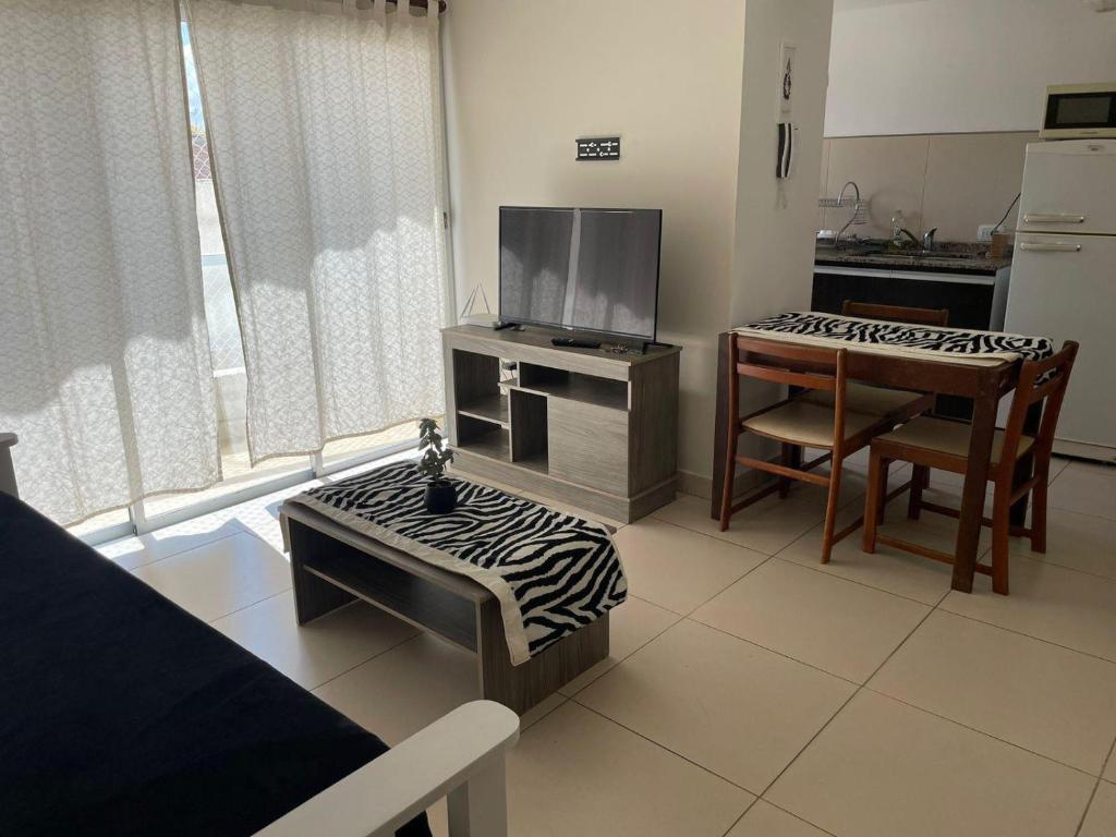 een woonkamer met een televisie en een eettafel bij Avenida Belgrano in Salta