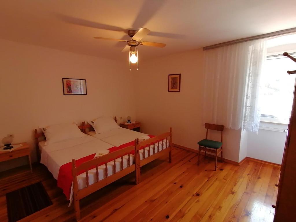 um quarto com uma cama e uma ventoinha de tecto em Bernik rooms em Plomin