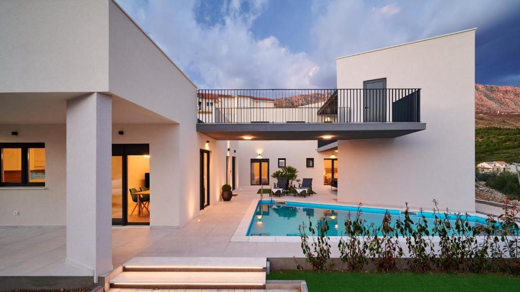 een modern huis met een zwembad en een balkon bij Villa AdriaStar in Dugi Rat