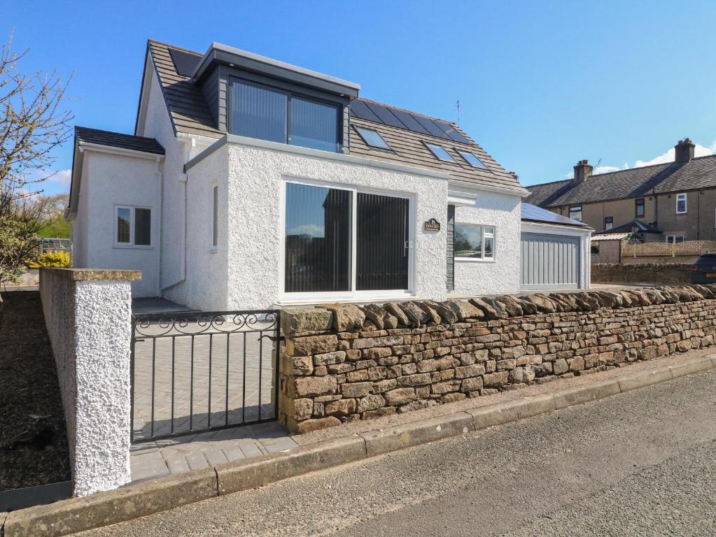 une maison blanche avec un mur en pierre dans l'établissement Fron Y Felin, à Carnforth