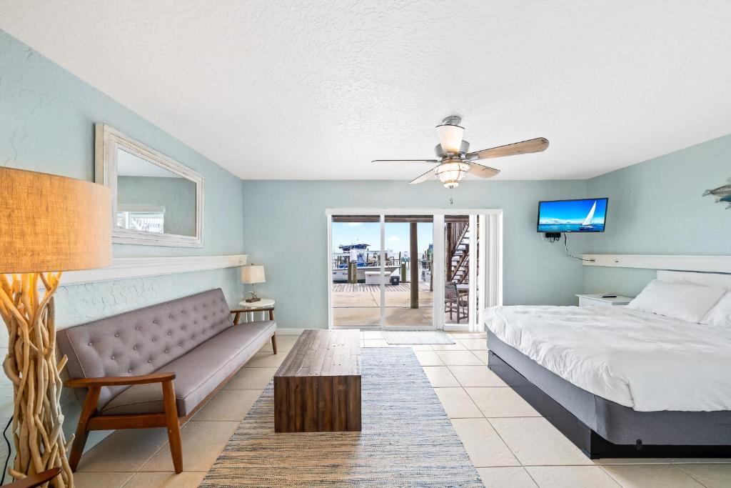 a bedroom with a bed and a couch and a tv at Sebastian Saltwater Lodge in Sebastian