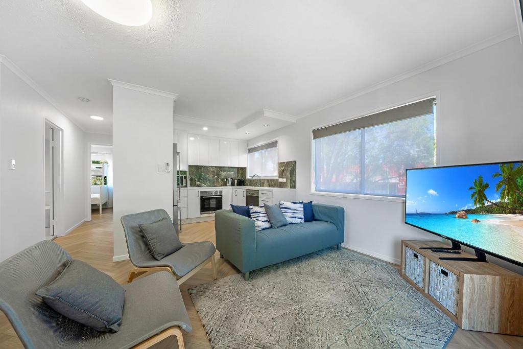 sala de estar con TV de pantalla plana grande en Newly Renovated Unit in Southport Gold Coast en Gold Coast