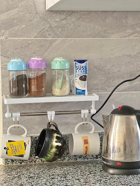 a kitchen shelf with jars and a tea kettle at Chalet in La Jolie Marina El Ain El Sokhna - Egyptian Families Only in Ain Sokhna