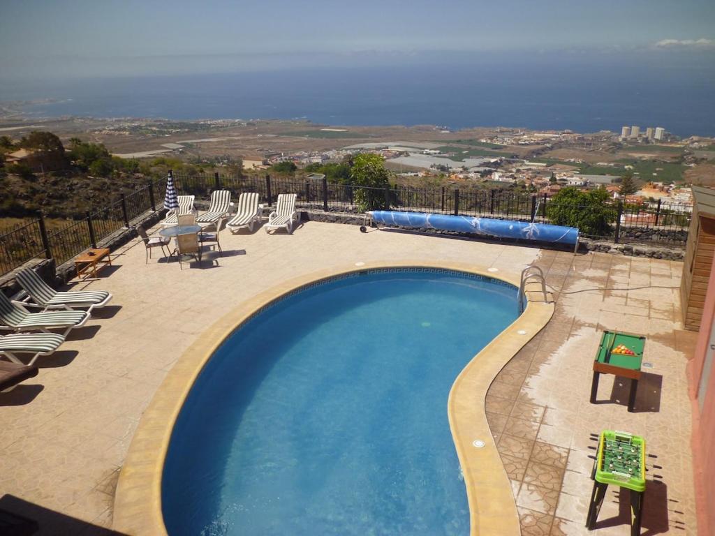 una piscina con tumbonas y vistas al océano en Villa El Mirador, en Los Menores