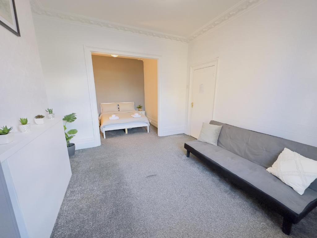 a living room with a couch and a table at Stratford House - SleepyLodge in London