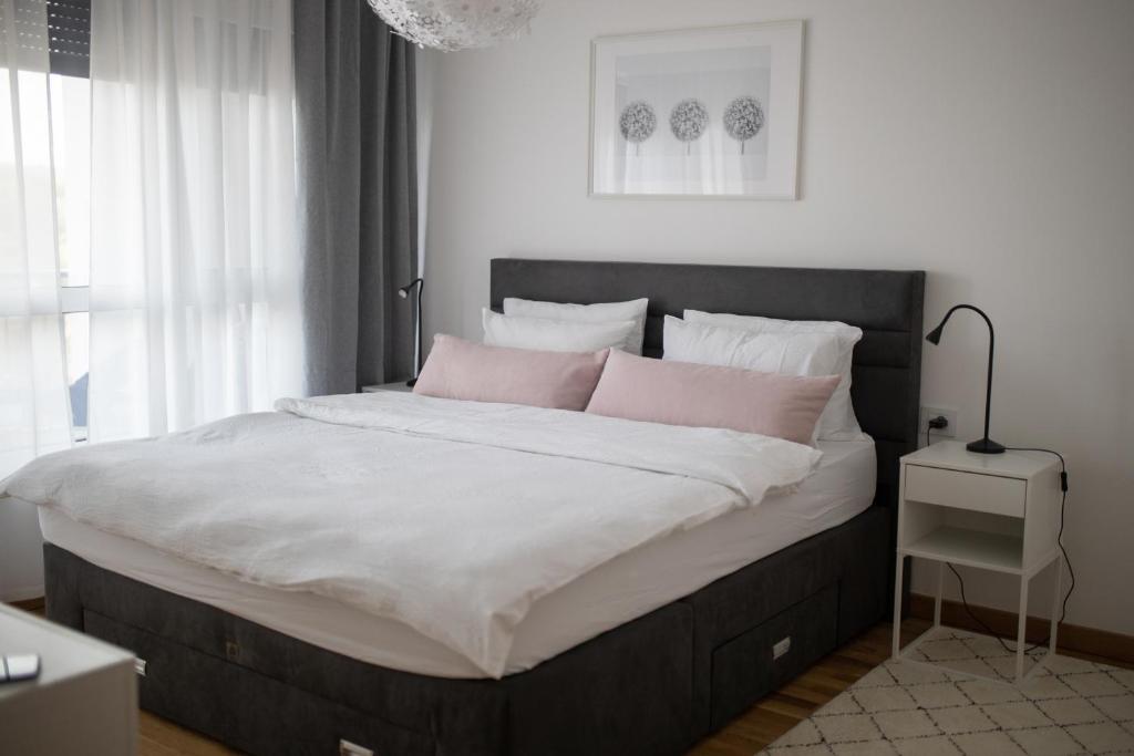 una camera da letto con un grande letto con cuscini rosa di A 207-Fruske Residence a Vrdnik