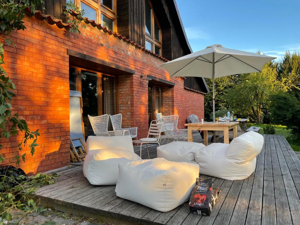 a patio with white furniture and an umbrella at Między Wodami in Węgorzewo