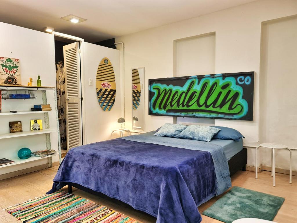 um quarto com uma cama com uma grande placa na parede em Beautiful house surrounded by nature with deck em Medellín