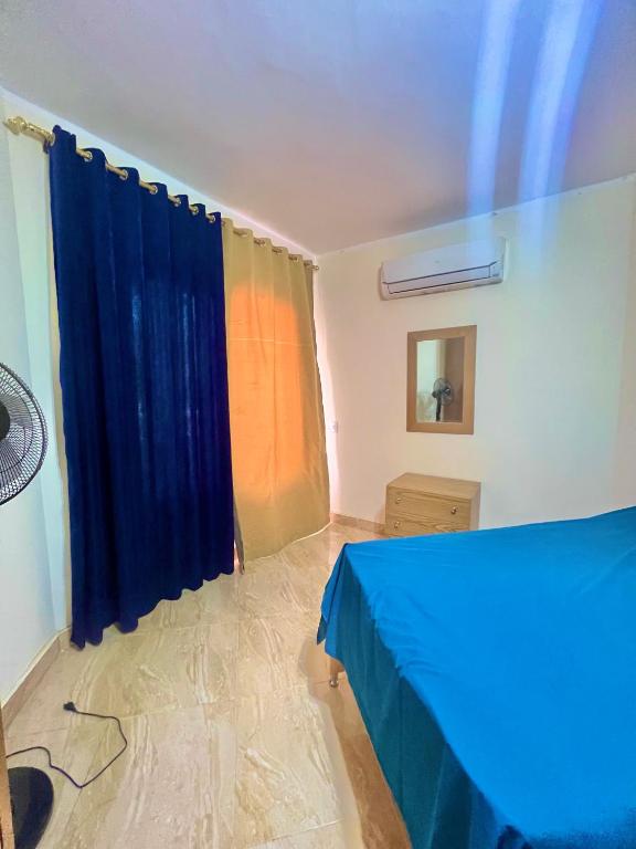 a bedroom with a blue bed and a window at Chalet in La Jolie Marina El Ain El Sokhna - Egyptian Families Only in Ain Sokhna