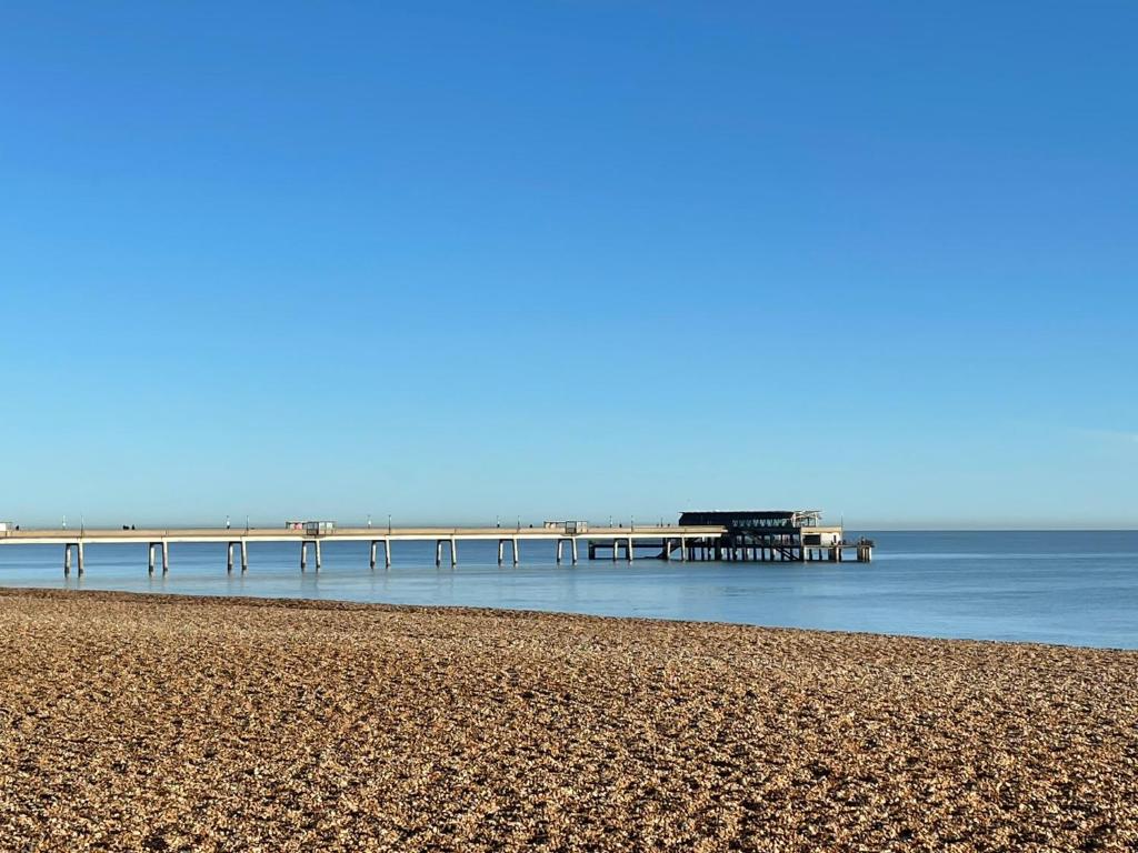 a beach with a pier in the water at Private Double en-suite Room at the Groves in Kent