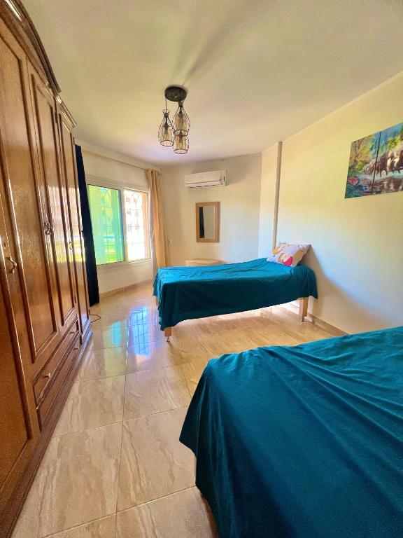a bedroom with two beds in a room with blue sheets at Chalet in La Jolie Marina El Ain El Sokhna - Egyptian Families Only in Ain Sokhna