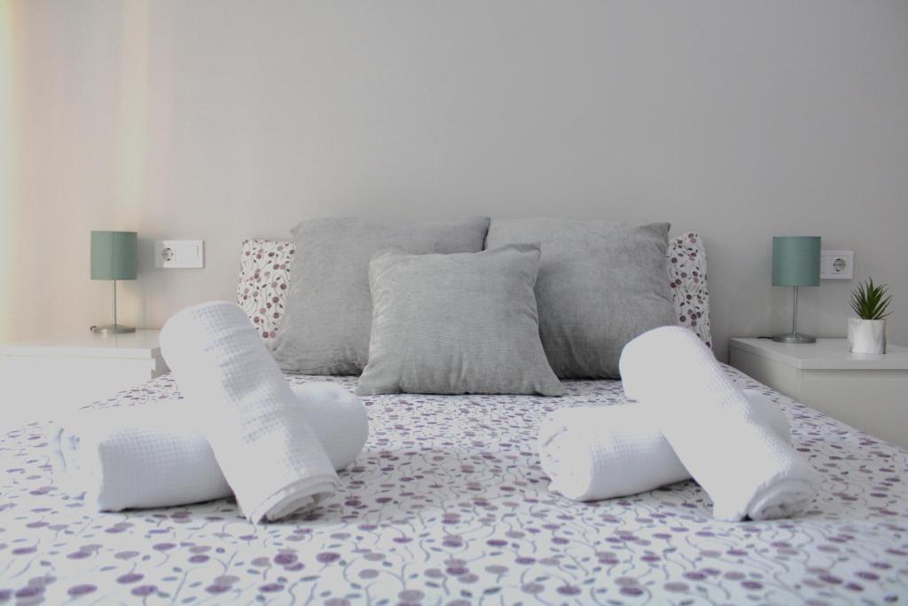 a white bed with two white pillows on it at Apartamento PLAYA 5 minutos a pie MODERNO Y CONFORTABLE CABANYAL in Valencia