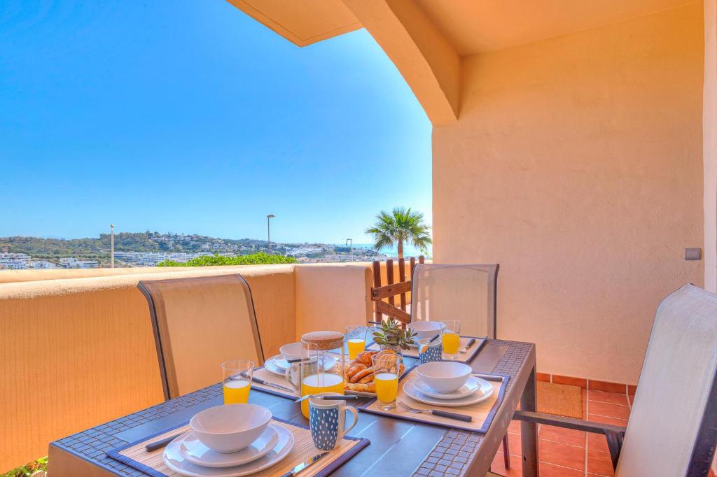 stół z talerzami żywności na balkonie w obiekcie CALA BLUE VIEWS w mieście La Cala de Mijas