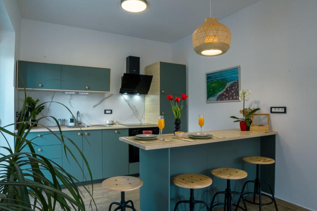 a kitchen with blue cabinets and bar stools at Deluxe Apartment and Studio "Nona Fa" in Rijeka