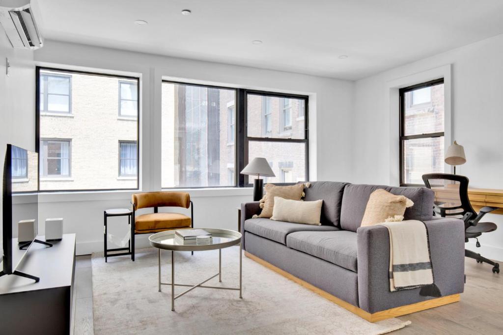 ein Wohnzimmer mit Sofa und Tisch in der Unterkunft UWS 2BR w WD Deck nr Central Park NYC-773 in New York