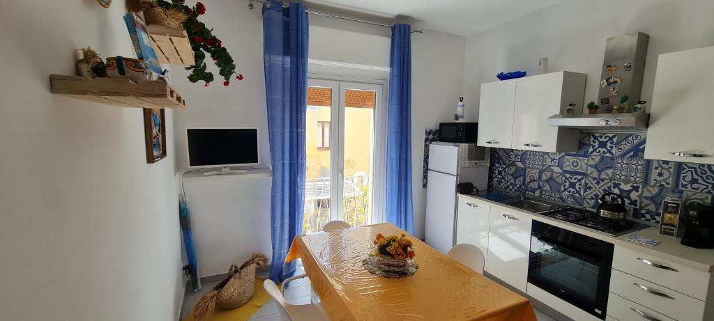 La Siciliana Trapani Apartment في تراباني: مطبخ صغير مع طاولة وموقد ونافذة