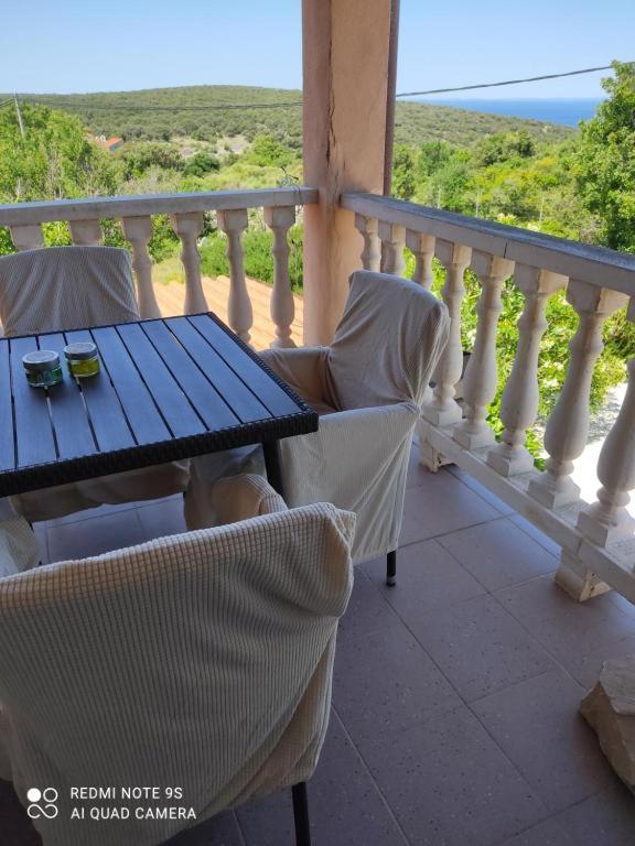 a table and chairs on a balcony with a view of the ocean at Apartments Nino in Štivan