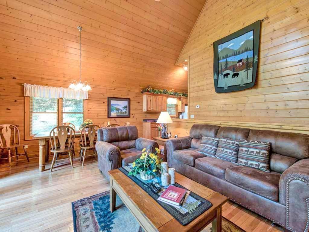 a living room with a couch and a table at Idle Days, 2 Bedrooms, Sleeps 8, Pool Table, Grill, Pool Access, WiFi in Gatlinburg