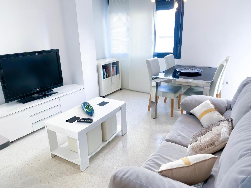 uma sala de estar com um sofá, uma televisão e uma mesa em El rinconcito de la Isla em San Fernando