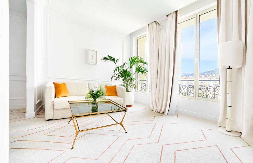 a living room with a couch and a table at Carlton Cannes, a Regent Hotel in Cannes