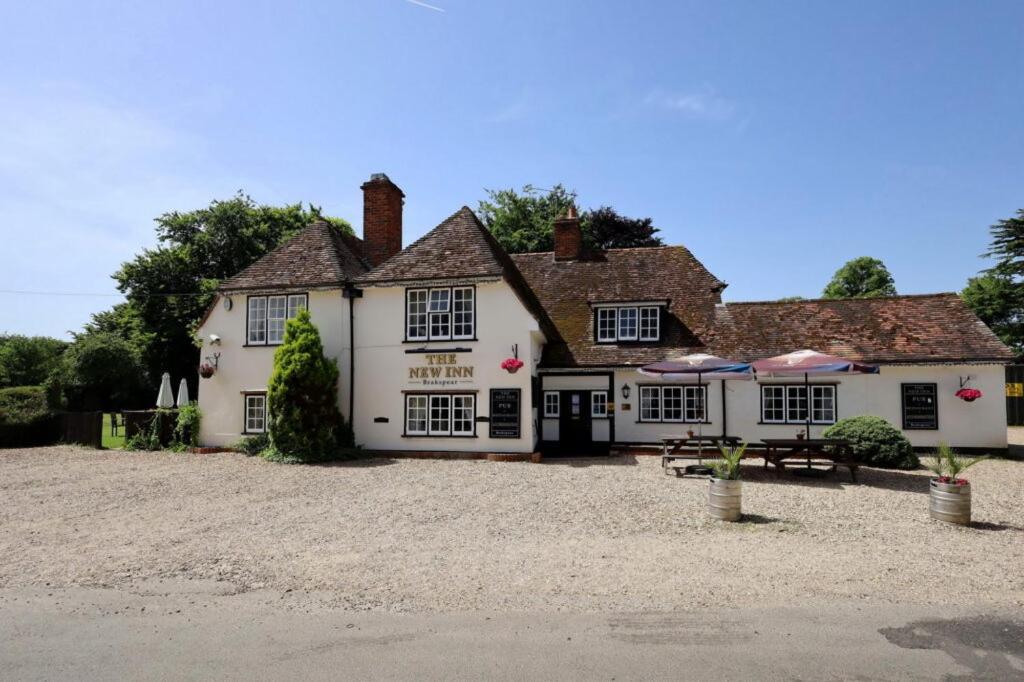 uma grande estalagem branca com uma entrada de cascalho em The New Inn em Reading