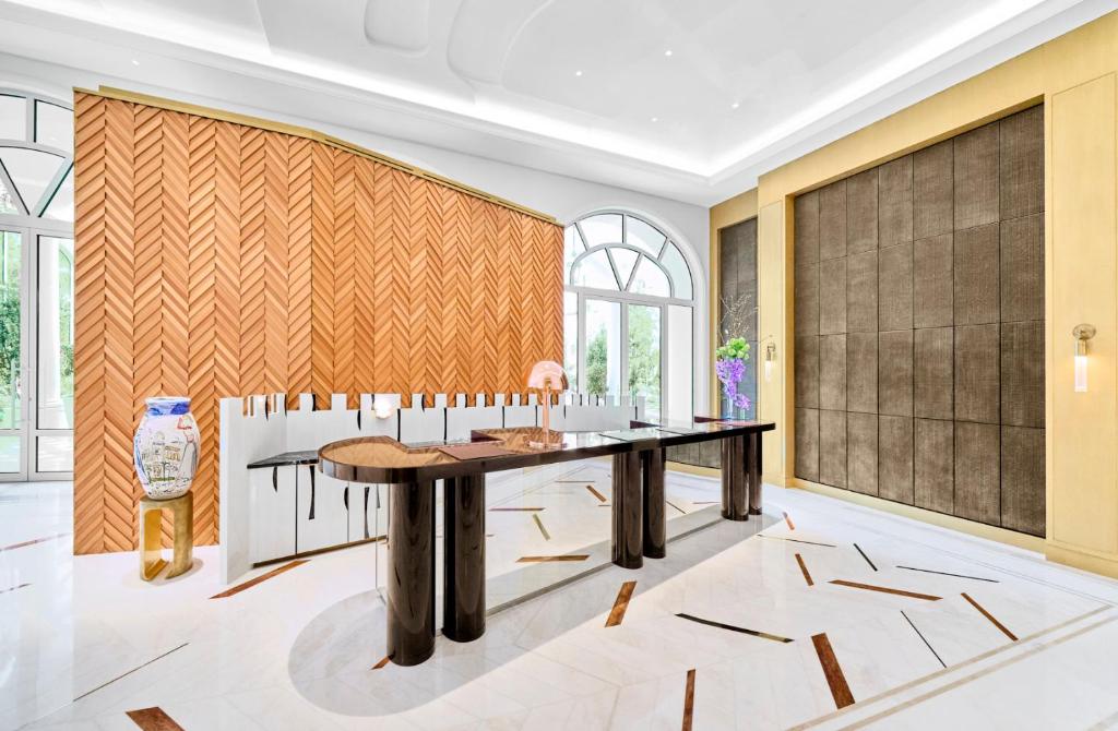a dining room with a table and a wall of windows at Carlton Cannes, a Regent Hotel in Cannes