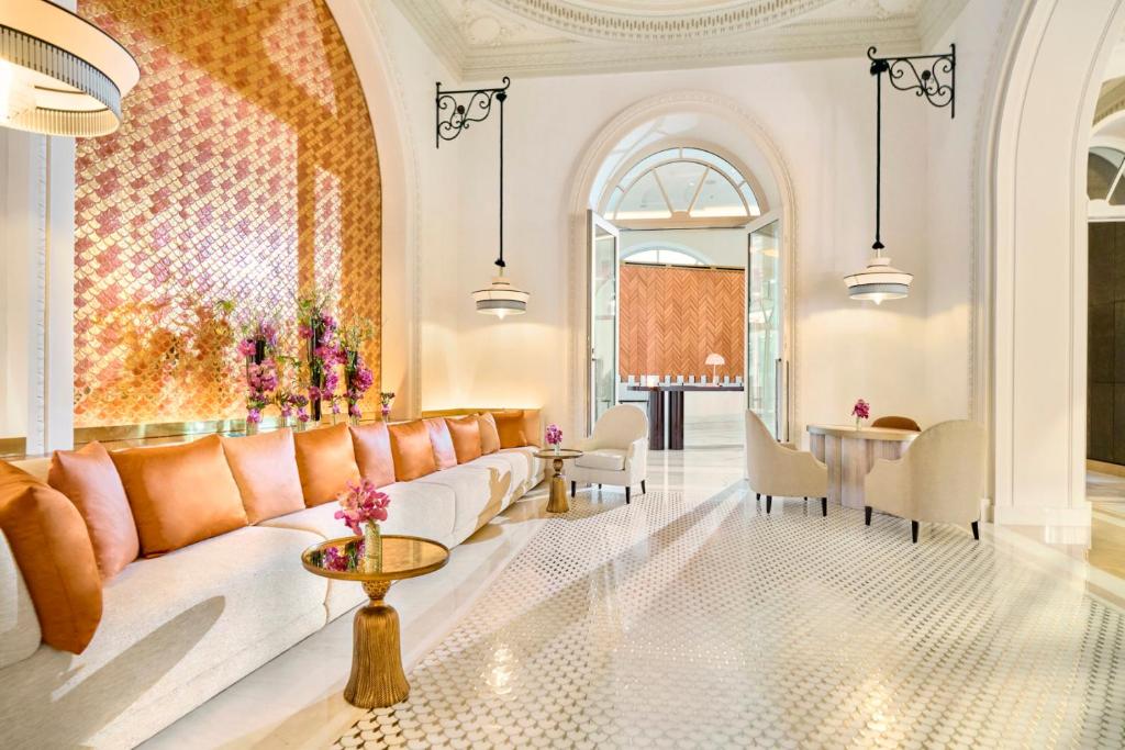 a living room with a couch and a table at Carlton Cannes, a Regent Hotel in Cannes