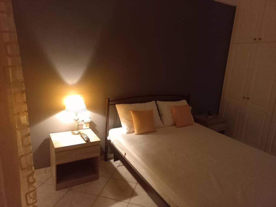 a bedroom with a bed with a lamp on a table at Stefkas apartment1 in Patra