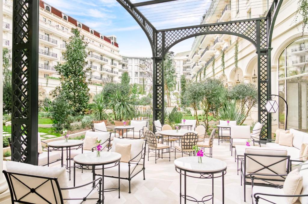an outdoor patio with tables and chairs in a building at Carlton Cannes, a Regent Hotel in Cannes
