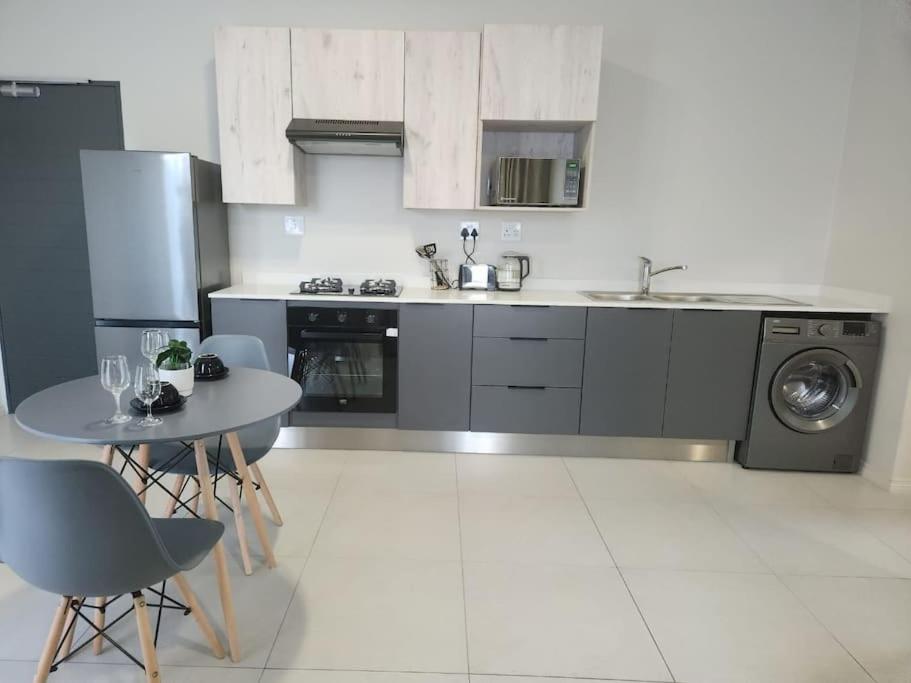 a kitchen with a sink and a table with chairs at 93 on new unique and classy in Midrand
