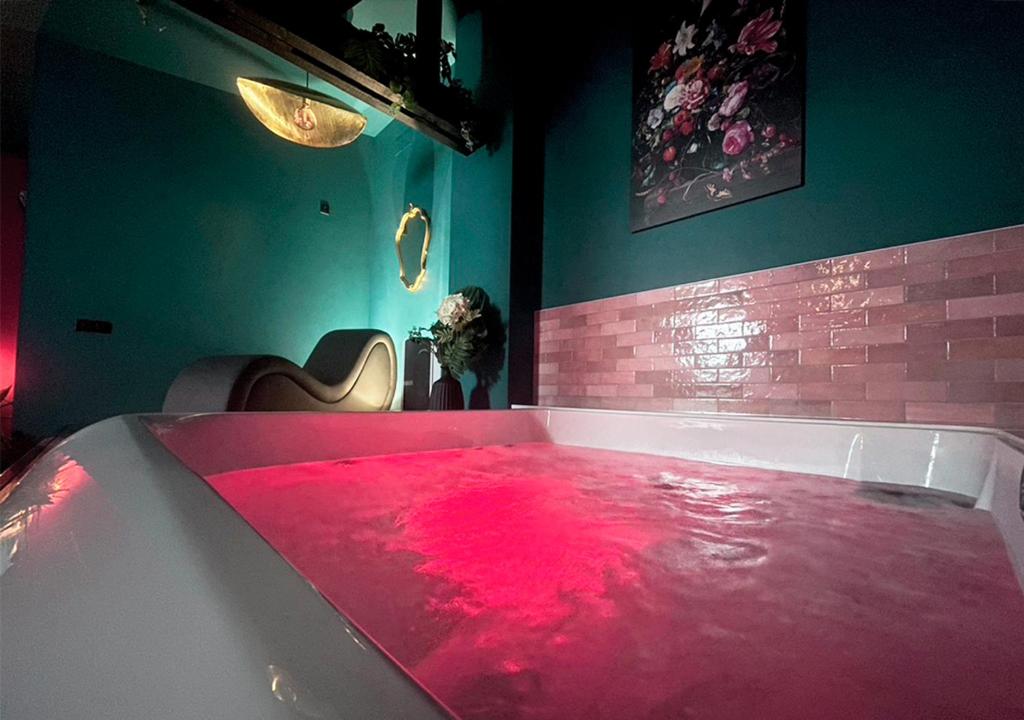 a bath tub filled with red water in a room at NUITS D'EXIL in Gérardmer