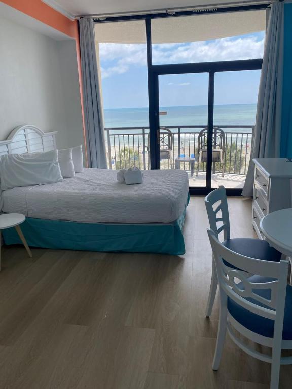 a bedroom with a bed and a view of the ocean at Breakers Resort in Myrtle Beach