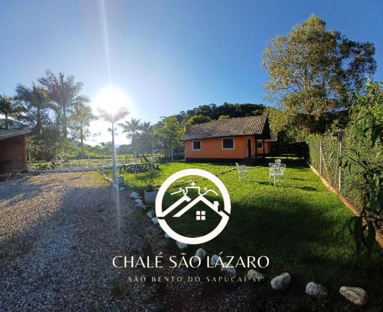 a sign in front of a house in a yard at Chalés São Lázaro in São Bento do Sapucaí