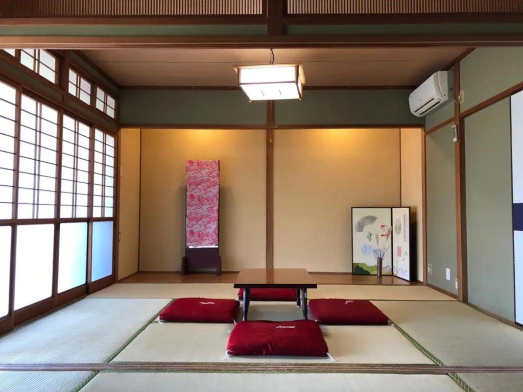 een kamer met een tafel in het midden van een kamer met ramen bij SABOJI - Vacation STAY 34252v in Takamori
