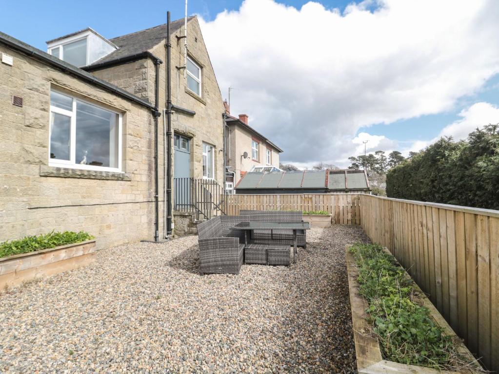 un patio con mesa y sillas frente a una casa en Butterchurn Apartment, en Newcastle