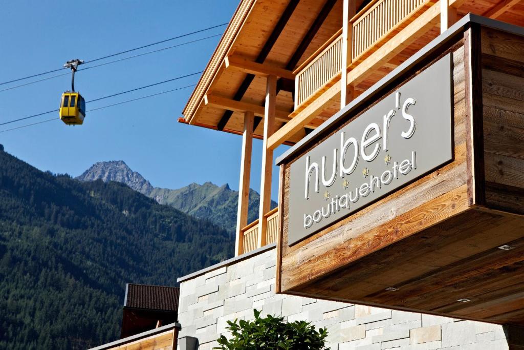 a sign on a building with mountains in the background at Huber's Boutique Hotel in Mayrhofen