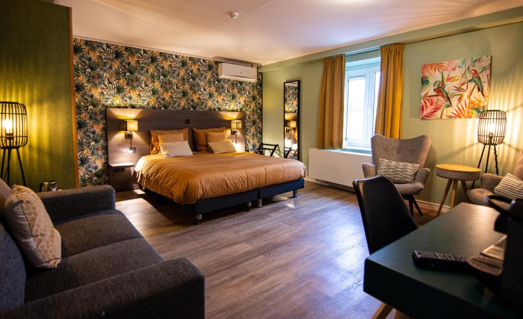 ズテンダールにあるHotel De Klokのベッドとソファ付きのホテルルーム
