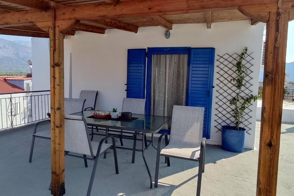 patio con mesa y sillas en el balcón en Αυτόνομο διαμέρισμα με θέα το Ιόνιο πέλαγος, en Mitikas