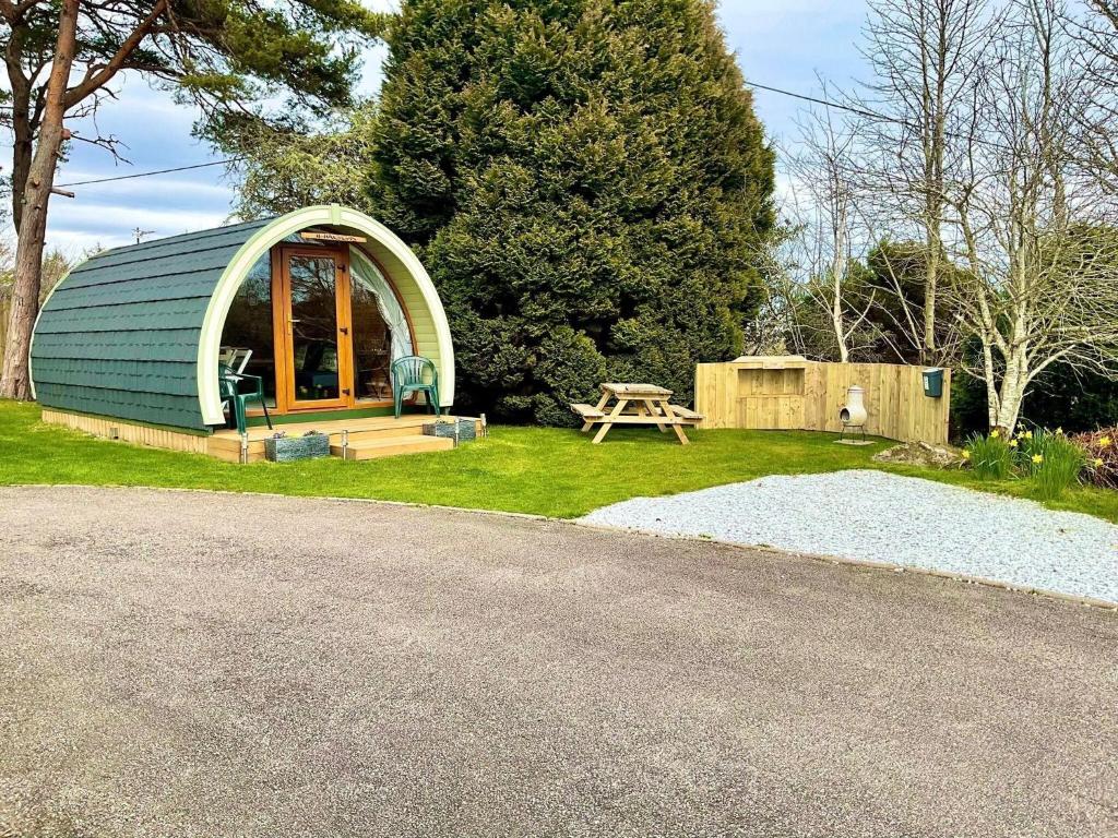a small dome house with a picnic table in the grass at Brora Pods in Brora
