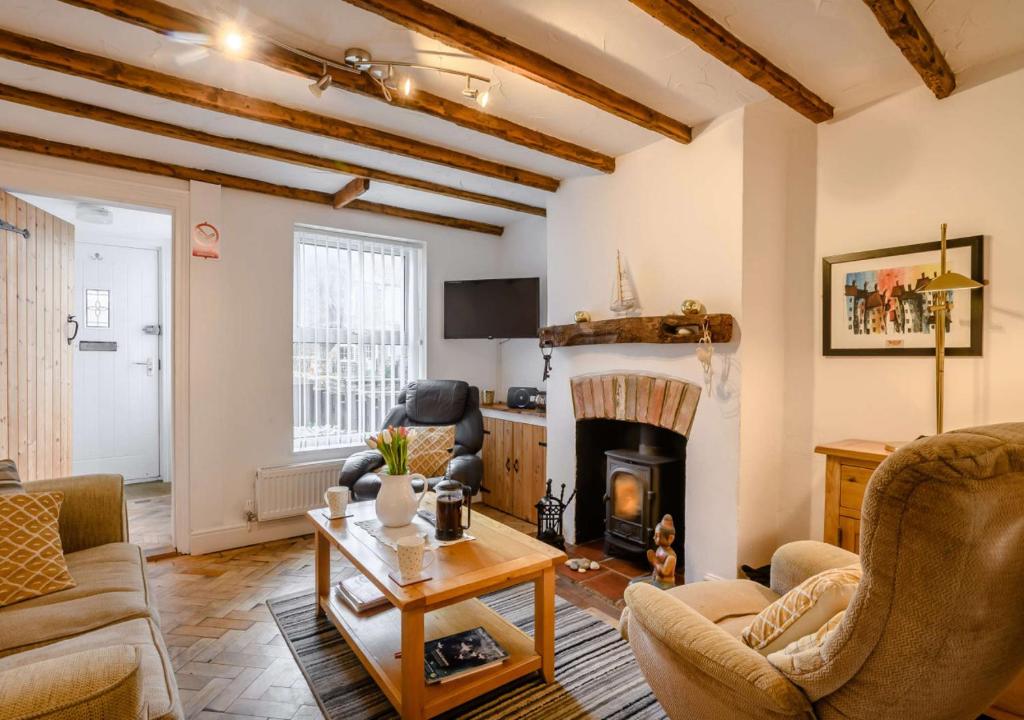 a living room with a couch and a fireplace at The Beach Hut in Lowestoft